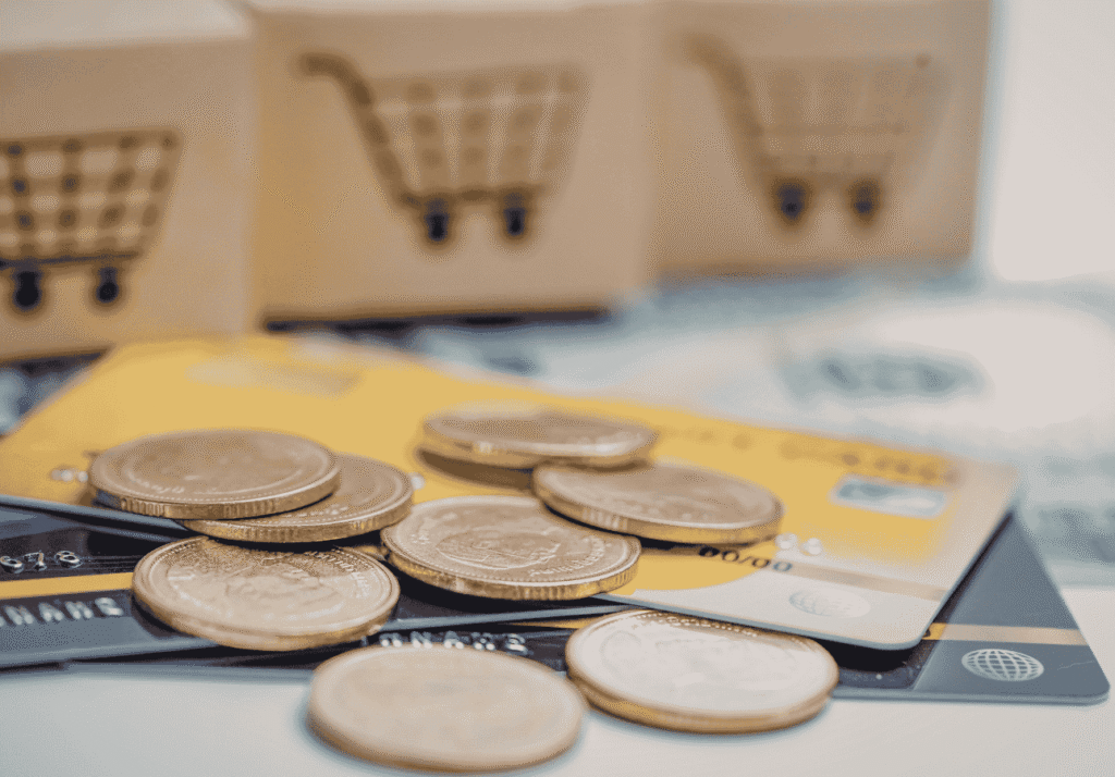 Coins stacked on top of credit cards representing cashback rewards from everyday spending.