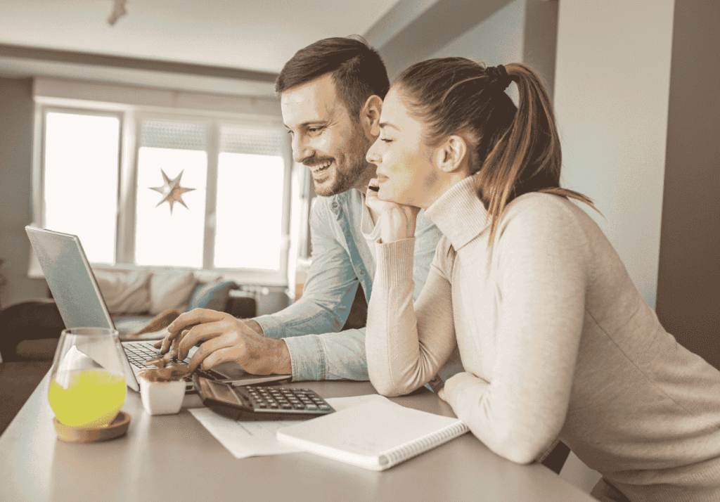 Couple reviewing their finances together on a laptop, preparing to automate their money management.