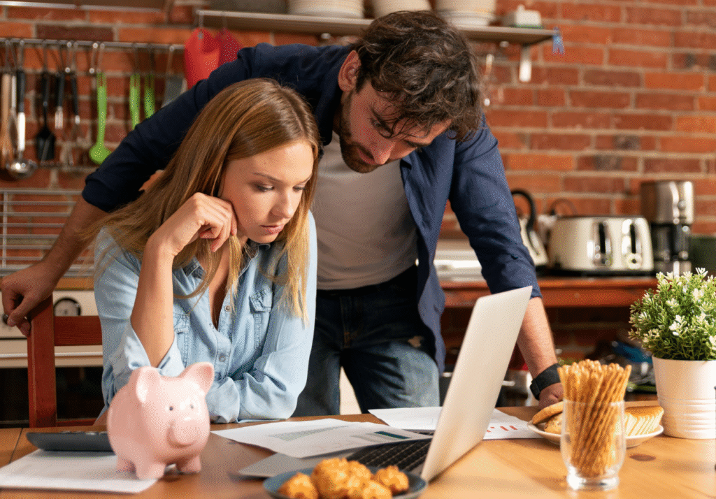common-emergency-fund-mistakes-canada-couple-budgeting Couple reviewing household finances and budgeting documents while making common emergency fund mistakes in Canada