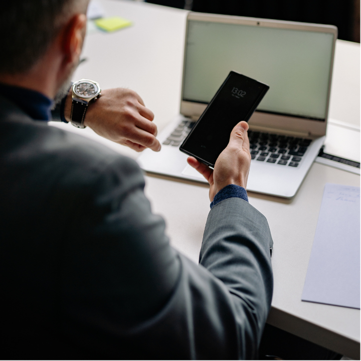 Man checking phone while reviewing finances, illustrating RRSP tax refund decision in Canada.