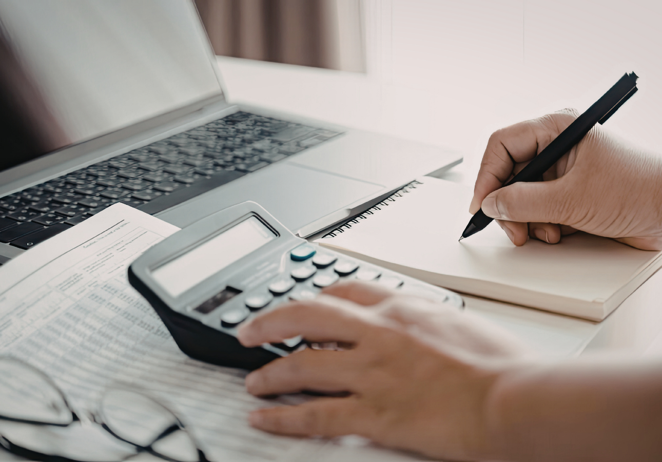 Person calculating credit card annual fee break-even math on a calculator with financial statements