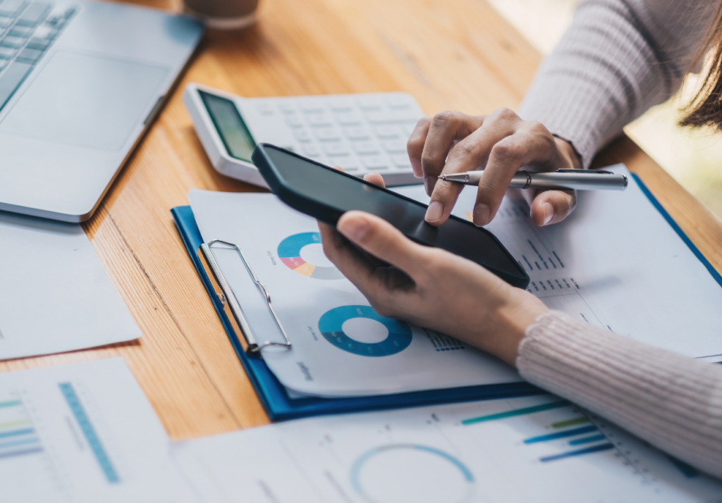 person reviewing financial data on phone and calculator for credit score calculation