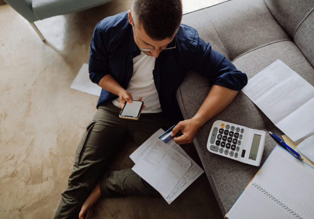 Person reviewing bills and credit card statement while working to improve credit score in Canada