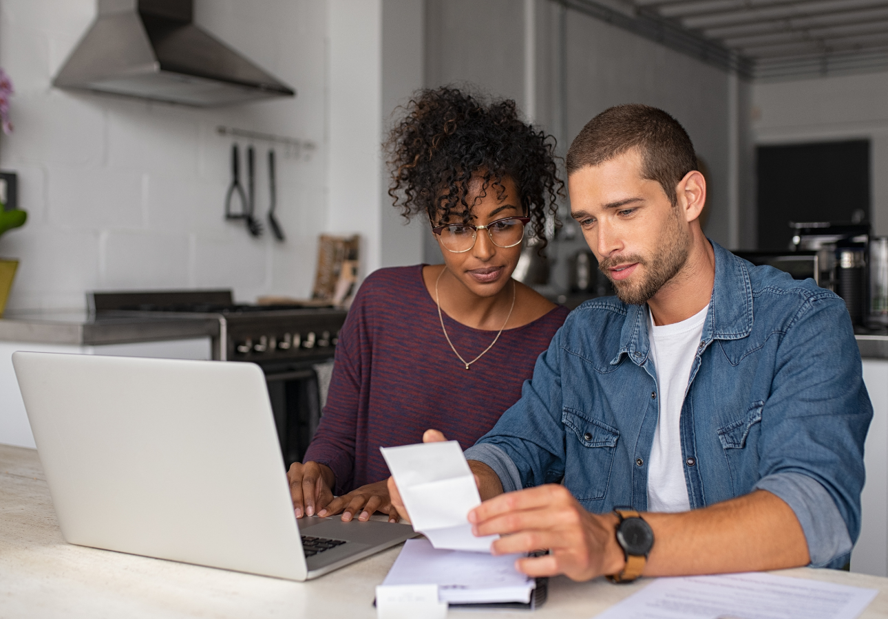 Canadian couple at kitchen table reviewing RRSP investment strategy on laptop