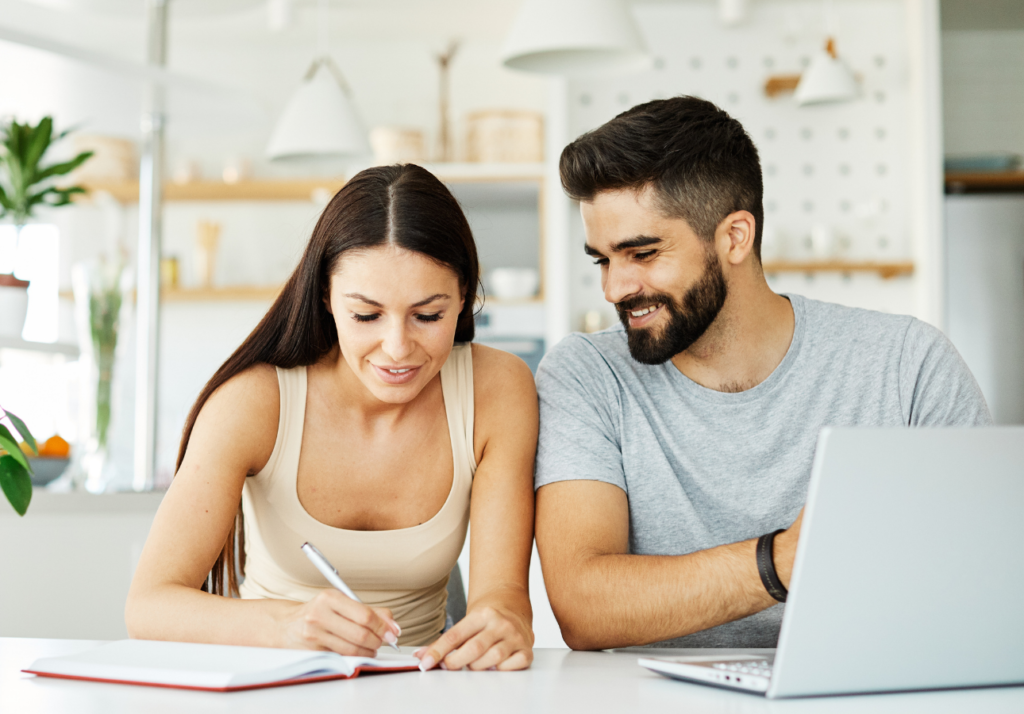 Couple reviewing finances and investing plans on a laptop at home in Canada